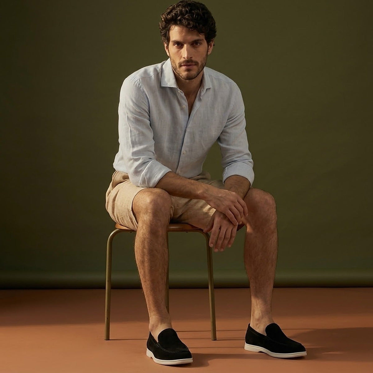 Anzio Loafer Black, worn with linen, on a stool