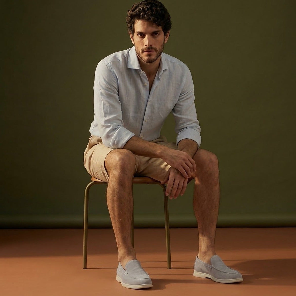 Anzio Loafer Fog Grey, worn with linen, on a stool